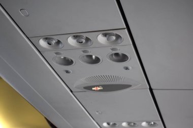 Ticari bir uçağın tepe noktasında aksesuarlar: sigara içilmiyor, ışık ve klima okunmuyor..
