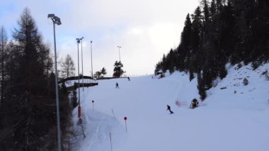 Dağdan inen kayakçılar ve snowboardcular. Avusturya Alplerinde yer alan Obergurgl kayak merkezinde sessiz kayak yamacı