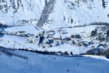 Yukarıdan karlı Obergurgl Avusturya kayak merkezi manzarası. Yükselen bir kayak asansöründen çekilen karlı Alp köyünün hava manzarası.