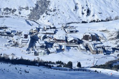 Yukarıdan karlı Obergurgl Avusturya kayak merkezi manzarası. Yükselen bir kayak asansöründen çekilen karlı Alp köyünün hava manzarası.