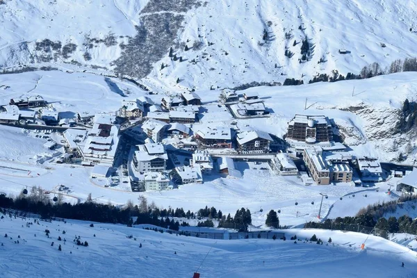 View of snowy Obergurgl Austrian ski resort from above. Aerial view of the snowy alpine village, shot from an ascending ski lift