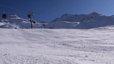 Bir sürü aktif kayakçı ve snowboardcu güneşli bir günde dağ yamacına iniyor. Avusturya Alplerinde yer alan Hochgurgl kayak merkezinde yoğun kayak yamacı.