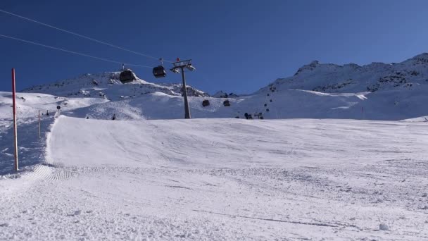 晴れた日にはスキーヤーやスノーボーダーが山の斜面を降りてきます オーストリアのアルプスに位置するホッググルスキーリゾートのアクティブなスキー場 — ストック動画