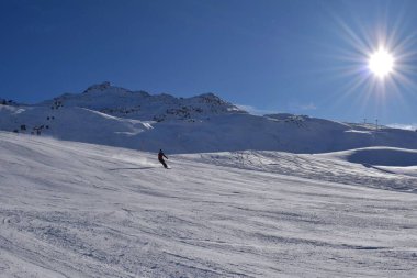 Hochgurgl 'daki kayakçılar ve snowboardcular güneşli güzel bir günde Otztal Vadisi' ndeki kar tepeli dağlarda kayak ve snowboard yapmak için mükemmel koşullar..