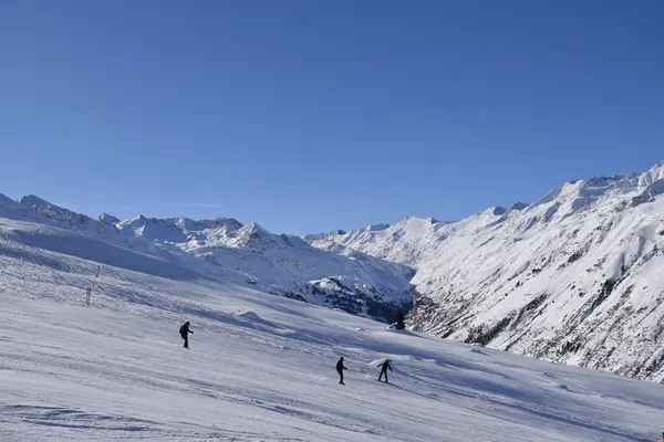 stock image Skiers and snowboarders in Hochgurgl ski resort, backdropped by the Otztal valley and the snow capped alpine mountains in Tyrol, Austria on a beautiful sunny day, perfect conditions for winter sports.