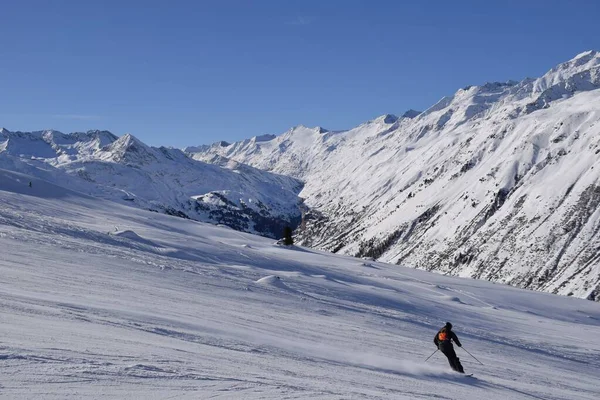 stock image Skiers and snowboarders in Hochgurgl ski resort, backdropped by the Otztal valley and the snow capped alpine mountains in Tyrol, Austria on a beautiful sunny day, perfect conditions for winter sports.