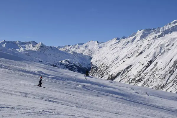 stock image Skiers and snowboarders in Hochgurgl ski resort, backdropped by the Otztal valley and the snow capped alpine mountains in Tyrol, Austria on a beautiful sunny day, perfect conditions for winter sports.