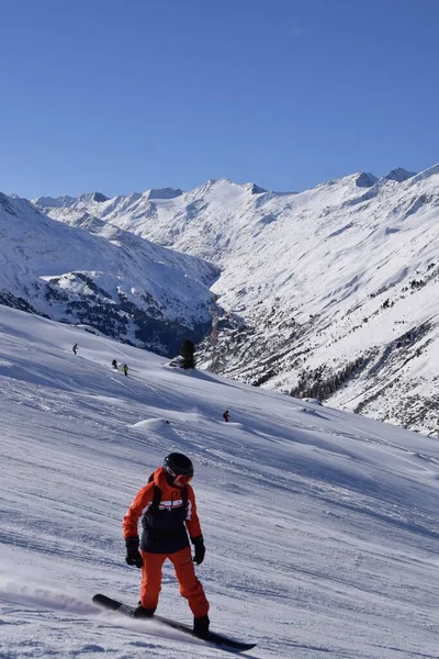 Hochgurgl kayak merkezindeki kayakçılar ve snowboardcular, Otztal Vadisi 'nin ve Avusturya' nın Tyrol kentindeki kar kaplı dağların arkasında güneşli bir günde, kış sporları için mükemmel koşullar..