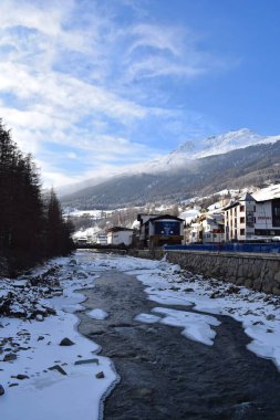 Solden, Tyrol, Avusturya - 27 Ocak 2023: Solden Alp tatil beldesindeki Otztal Vadisi 'nden geçen buzlu nehir. Avusturya 'nın geleneksel Solden kasabası kış aylarında en yoğun kayak sezonunda.