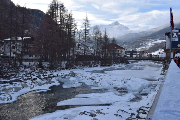 Solden Alp Oteli 'ndeki Otztal Vadisi' nden akan donmuş bir nehrin güzel manzarası. Avusturya 'nın geleneksel Solden kasabası kış aylarında zirve yapan kayak sezonunda. Dağ arkaplanı.