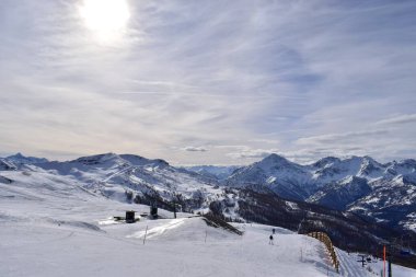 İtalya 'nın Turin, İtalya' daki Sauze D 'Oulx kayak merkezindeki kayak yamacından muhteşem bir manzara ve vadi. Piedmont bölgesinde karlı dağlardan oluşan güzel İtalyan dağları.