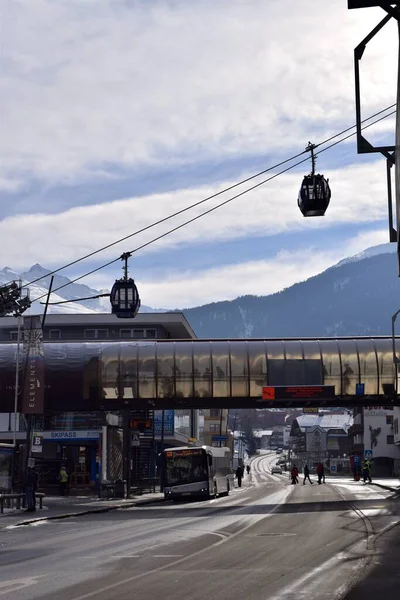 Solden, Tyrol, Avusturya - 27 Ocak 2023: Solden kasabasındaki bir nakliye istasyonundan kalkan Gondola kayak ve snowboard asansörü. Kayakçılar ve snowboardcular asansörün altında köprüden geçiyorlar..