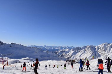 Cervinia Valtournenche, Aosta Vadisi, İtalya - 25 Aralık 2019: Kayakçılar ve snowboardcular Cervinia kış sporları kayak merkezinde piste çıktılar. Pennine Alpleri 'nin karla kaplı İtalyan dağ zirveleri