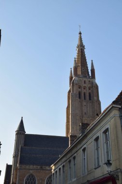 Bruges, Belçika - 8 Haziran 2023: The Church of Our Lady, Bruges, Belçika 'da bir Roma Katolik kilisesi. Kulesi tarihi kentin en yüksek binası ve dünyanın en yüksek ikinci tuğla kulesidir..