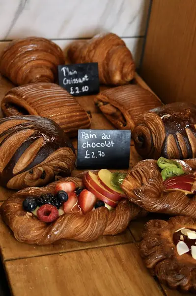 stock image Sweet butter puff pastries in an Italian artisan bakery. Pain au chocolat pastries, croissants and fruit tarts