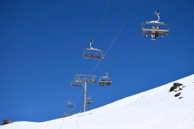 Bir Fransız kayak merkezinde açık ve güneşli bir günde kayakçılar ve snowboardcular için sandalye kaldırma