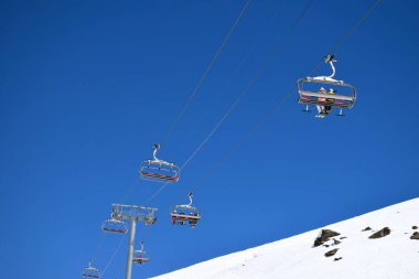 Bir Fransız kayak merkezinde açık ve güneşli bir günde kayakçılar ve snowboardcular için sandalye kaldırma