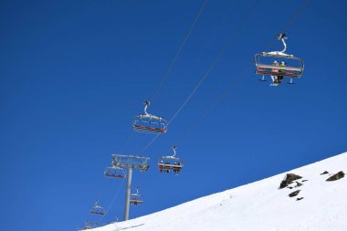 Bir Fransız kayak merkezinde açık ve güneşli bir günde kayakçılar ve snowboardcular için sandalye kaldırma