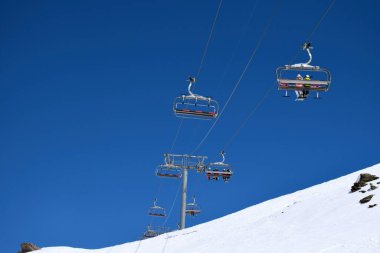 Bir Fransız kayak merkezinde açık ve güneşli bir günde kayakçılar ve snowboardcular için sandalye kaldırma