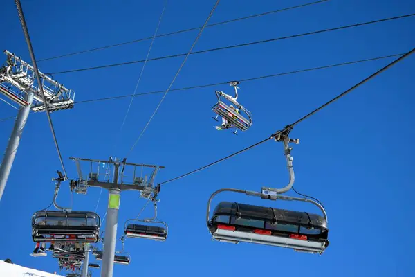 stock image Overhead chair lifts for skiers and snowboarders on a clear, sunny day in a French ski resort