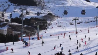 Kayakçılar sabahleyin Les Menuires Kayak Tesisi 'nin merkez bölgesinde toplanarak Üç Vadi' deki Fransız Alp Dağları 'nda kayak ve snowboard' la güzel bir gün geçirdiler..