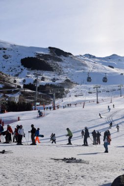Les Menuires - 11 Mart 2024: Kayakçılar sabah Les Menuires Kayak Tesisi 'nin Üs Bölgesi' nde toplanarak Üç Vadi 'deki Fransız Alp Dağları' nda kayak ve snowboard sporu için güzel bir gün geçirdiler..