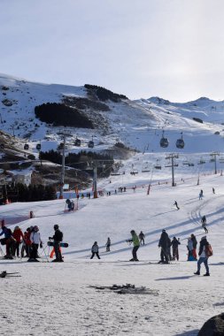 Les Menuires - 11 Mart 2024: Kayakçılar sabah Les Menuires Kayak Tesisi 'nin Üs Bölgesi' nde toplanarak Üç Vadi 'deki Fransız Alp Dağları' nda kayak ve snowboard sporu için güzel bir gün geçirdiler..
