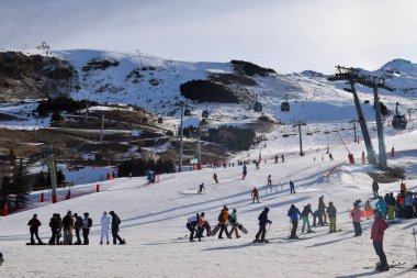 Les Menuires - 11 Mart 2024: Kayakçılar sabah Les Menuires Kayak Tesisi 'nin Üs Bölgesi' nde toplanarak Üç Vadi 'deki Fransız Alp Dağları' nda kayak ve snowboard sporu için güzel bir gün geçirdiler..