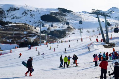 Les Menuires - 11 Mart 2024: Kayakçılar sabah Les Menuires Kayak Tesisi 'nin Üs Bölgesi' nde toplanarak Üç Vadi 'deki Fransız Alp Dağları' nda kayak ve snowboard sporu için güzel bir gün geçirdiler..