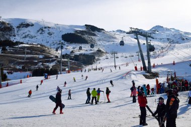 Les Menuires - 11 Mart 2024: Kayakçılar sabah Les Menuires Kayak Tesisi 'nin Üs Bölgesi' nde toplanarak Üç Vadi 'deki Fransız Alp Dağları' nda kayak ve snowboard sporu için güzel bir gün geçirdiler..