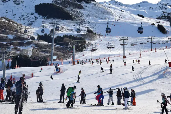Les Menuires - 11 Mart 2024: Kayakçılar sabah Les Menuires Kayak Tesisi 'nin Üs Bölgesi' nde toplanarak Üç Vadi 'deki Fransız Alp Dağları' nda kayak ve snowboard sporu için güzel bir gün geçirdiler..