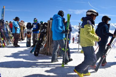 Meribel, Fransa - 13 Mart 2024: Fransa 'nın Üç Vadisi' ndeki Meribel ve Courchevel kayak merkezlerinin tepesinde bir grup kayakçı. Kayakçılar ve snowboardcular Saulire dağının zirvesinde toplandılar.