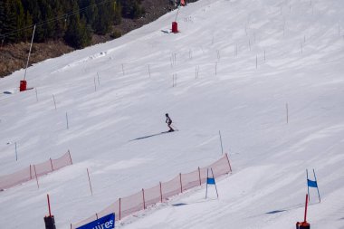 Les Menuires, Fransa - 14 Mart 2024: Aksiyon yarışı slalom kayağı sporcuları yüksek hızlarda dönüyor. Les Menuires kayak merkezindeki kayak pistlerinde performans sergileyen gelişmiş kayakçılar. Koltuk asansöründen görünüm.