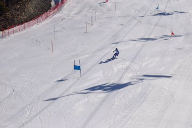 Les Menuires, Fransa - 14 Mart 2024: Aksiyon yarışı slalom kayağı sporcuları yüksek hızlarda dönüyor. Les Menuires kayak merkezindeki kayak pistlerinde performans sergileyen gelişmiş kayakçılar. Koltuk asansöründen görünüm.