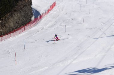 Les Menuires, Fransa - 14 Mart 2024: Aksiyon yarışı slalom kayağı sporcuları yüksek hızlarda dönüyor. Les Menuires kayak merkezindeki kayak pistlerinde performans sergileyen gelişmiş kayakçılar. Koltuk asansöründen görünüm.