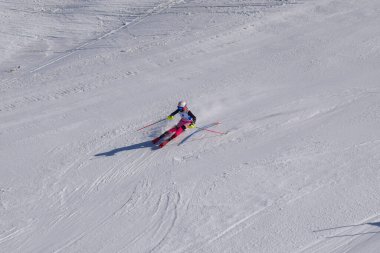Les Menuires, Fransa - 14 Mart 2024: Aksiyon yarışı slalom kayağı sporcuları yüksek hızlarda dönüyor. Les Menuires kayak merkezindeki kayak pistlerinde performans sergileyen gelişmiş kayakçılar. Koltuk asansöründen görünüm.