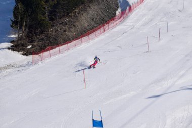 Les Menuires, Fransa - 14 Mart 2024: Aksiyon yarışı slalom kayağı sporcuları yüksek hızlarda dönüyor. Les Menuires kayak merkezindeki kayak pistlerinde performans sergileyen gelişmiş kayakçılar. Koltuk asansöründen görünüm.