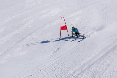 Les Menuires, Fransa - 14 Mart 2024: Aksiyon yarışı slalom kayağı sporcuları yüksek hızlarda dönüyor. Les Menuires kayak merkezindeki kayak pistlerinde performans sergileyen gelişmiş kayakçılar. Koltuk asansöründen görünüm.