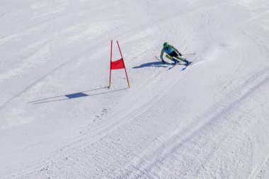 Les Menuires, Fransa - 14 Mart 2024: Aksiyon yarışı slalom kayağı sporcuları yüksek hızlarda dönüyor. Les Menuires kayak merkezindeki kayak pistlerinde performans sergileyen gelişmiş kayakçılar. Koltuk asansöründen görünüm.