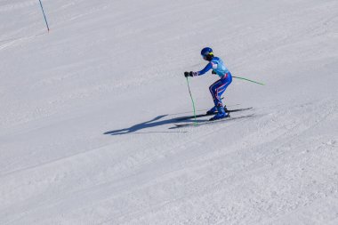 Les Menuires, Fransa - 14 Mart 2024: Aksiyon yarışı slalom kayağı sporcuları yüksek hızlarda dönüyor. Les Menuires kayak merkezindeki kayak pistlerinde performans sergileyen gelişmiş kayakçılar. Koltuk asansöründen görünüm.
