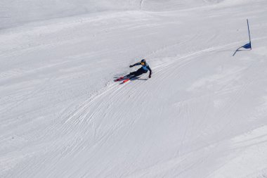 Les Menuires, Fransa - 14 Mart 2024: Aksiyon yarışı slalom kayağı sporcuları yüksek hızlarda dönüyor. Les Menuires kayak merkezindeki kayak pistlerinde performans sergileyen gelişmiş kayakçılar. Koltuk asansöründen görünüm.