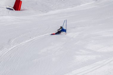 Les Menuires, Fransa - 14 Mart 2024: Aksiyon yarışı slalom kayağı sporcuları yüksek hızlarda dönüyor. Les Menuires kayak merkezindeki kayak pistlerinde performans sergileyen gelişmiş kayakçılar. Koltuk asansöründen görünüm.