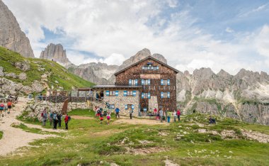 Rotwandhtte 'nin (Rifugio Roda di Val) İtalyan dolomitlerindeki dağ kulübesinde yaz manzarası. Harika bir yürüyüş yeri. Kulübenin önünde bir sürü yürüyüşçü var. 13 Temmuz 2024, Roda de Vael, İtalya