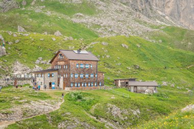 Rotwandhtte 'nin (Rifugio Roda di Val) İtalyan dolomitlerindeki dağ kulübesinde yaz manzarası. Harika bir yürüyüş yeri. Kulübenin önünde bir sürü yürüyüşçü var. 13 Temmuz 2024, Roda de Vael, İtalya