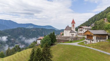 Bressanone (Brixen) yakınlarındaki Eores (Afers) kasabasının hava aracı görüntüsü. Bulutlu bir yaz günü. Merkezdeki San Giorgio Kilisesi 'ne bakın. İtalyan Dolomitlerinin İdilik dağ köyü.