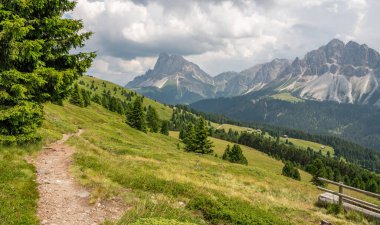 İtalyan dolomitlerindeki funes vadisinin hava aracı görüntüsü. Arka planda Peitlerkofel (Sass de Putia). Önünde çam ağaçları olan dağlık çayırlar. İtalyan dolomitleri. Harika bir yürüyüş alanı..