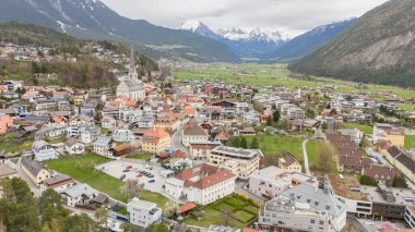 Aerial winter view of the city centre of Imst in Tirol. Beautiful city view Pfarrkirche Imst. city centre of Imst in Tirol. Rauchberg and Heiterwand mountain in the background and Pfarrkirche Imst. Tourist travel destination in Tyrol, Austria. clipart