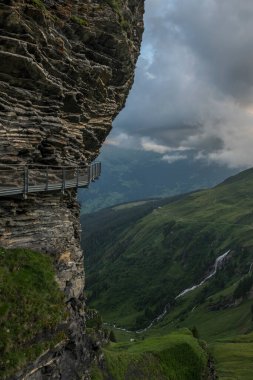 İsviçre 'nin Grindelwald kentindeki dağın yamacına ilk uçurum yürüyüşünde akşam manzarası vardı. Alp manzaralı arka planda. Kötü hava yakında geliyor..