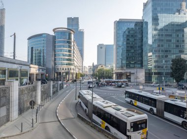 18 Temmuz 2024, Brüksel 'den Rogier Meydanı' na doğru. Sokakta halk otobüsleri. Modern ofis binaları. Yayalar, sokaktaki banliyö sakinleri. 