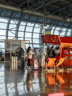 Brussels airport, Belgium. People of different origin queuing for ordering some snack of drink at a market stall clipart